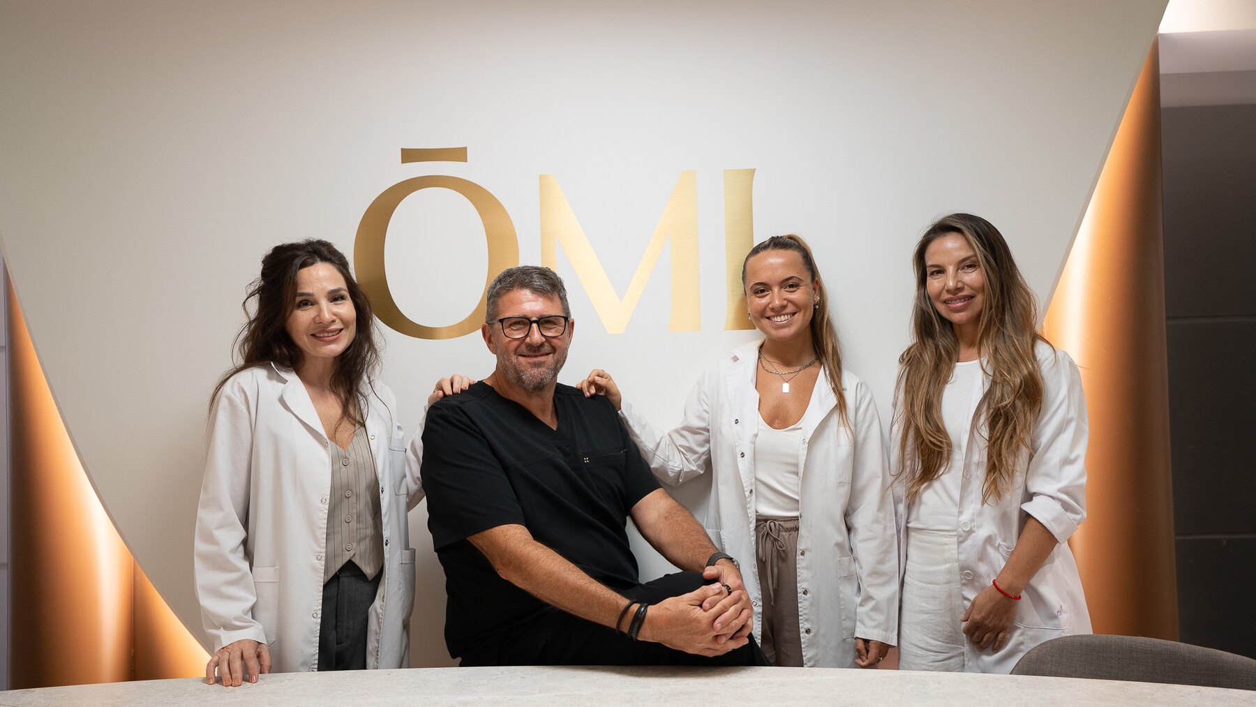 El equipo completo de ŌMI longevity frente al logotipo de la sede de Recoleta