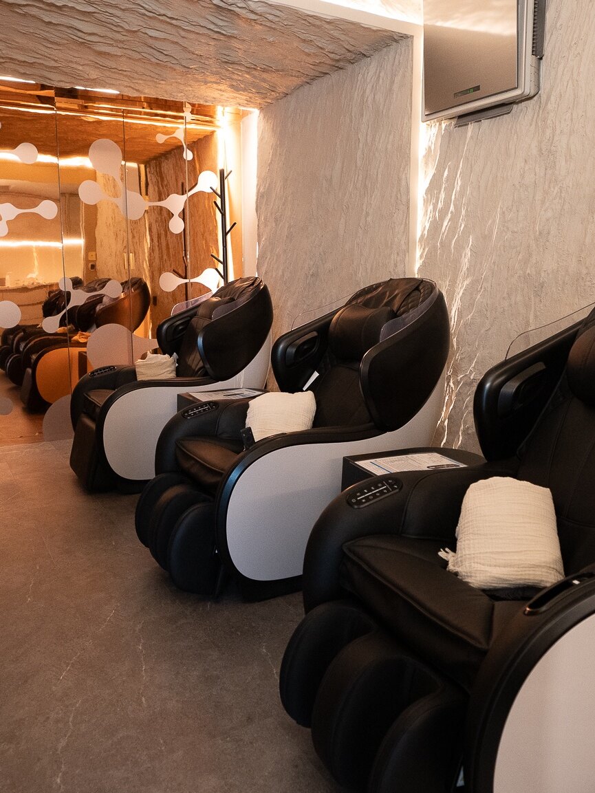 Sala de sueroterapia de ŌMI longevity, con los sillones alineados bajo luz cálida